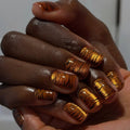 Metallic orange tiger-striped nails